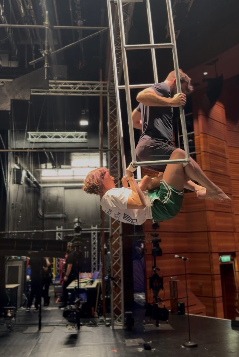 Acrobats on a frame trapeze photographed from off stage
