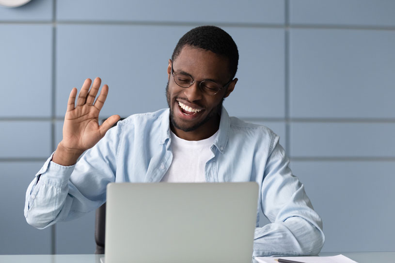 A man raises his hand on a video call