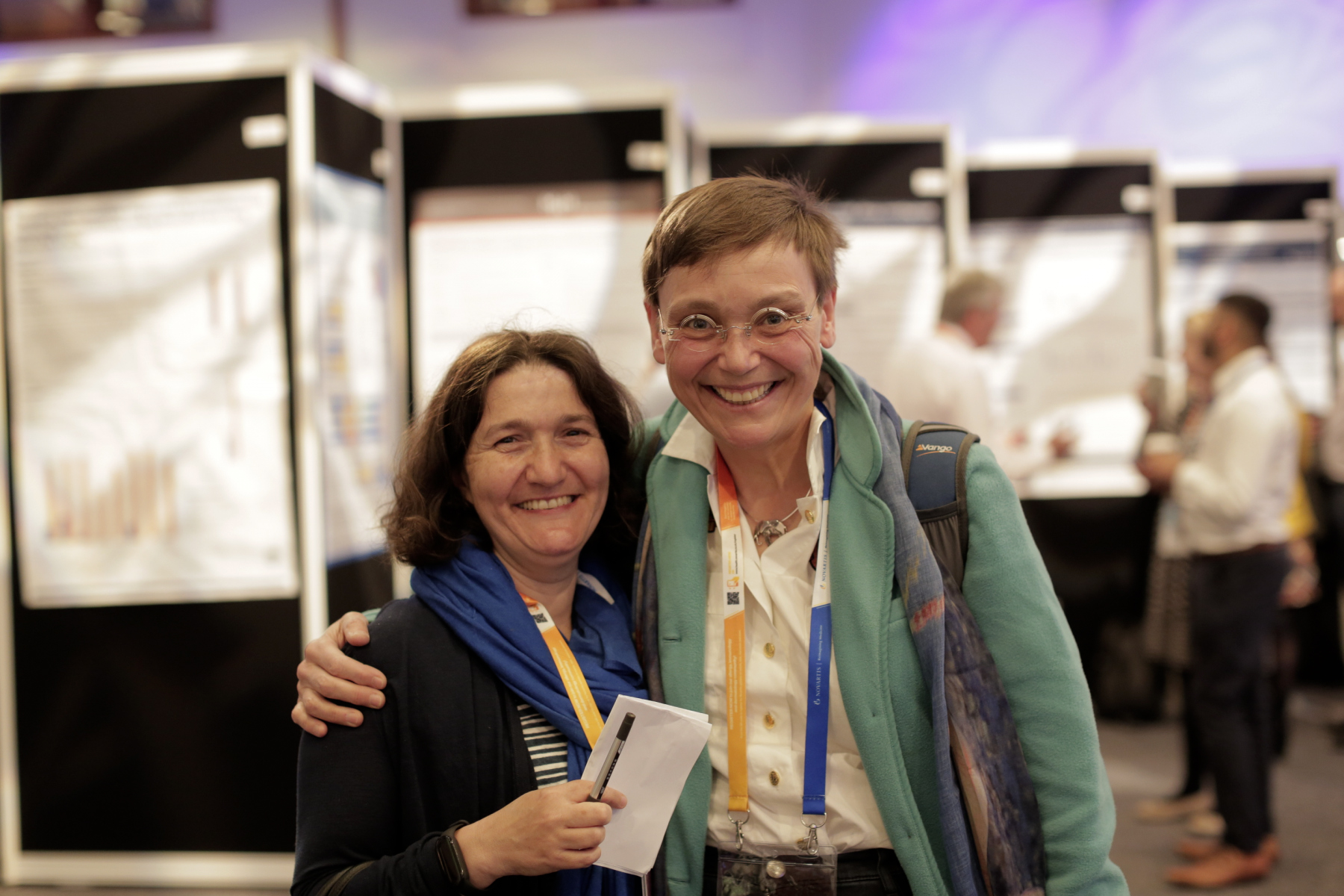 A pair of smiling delegates embrace, facing the camera